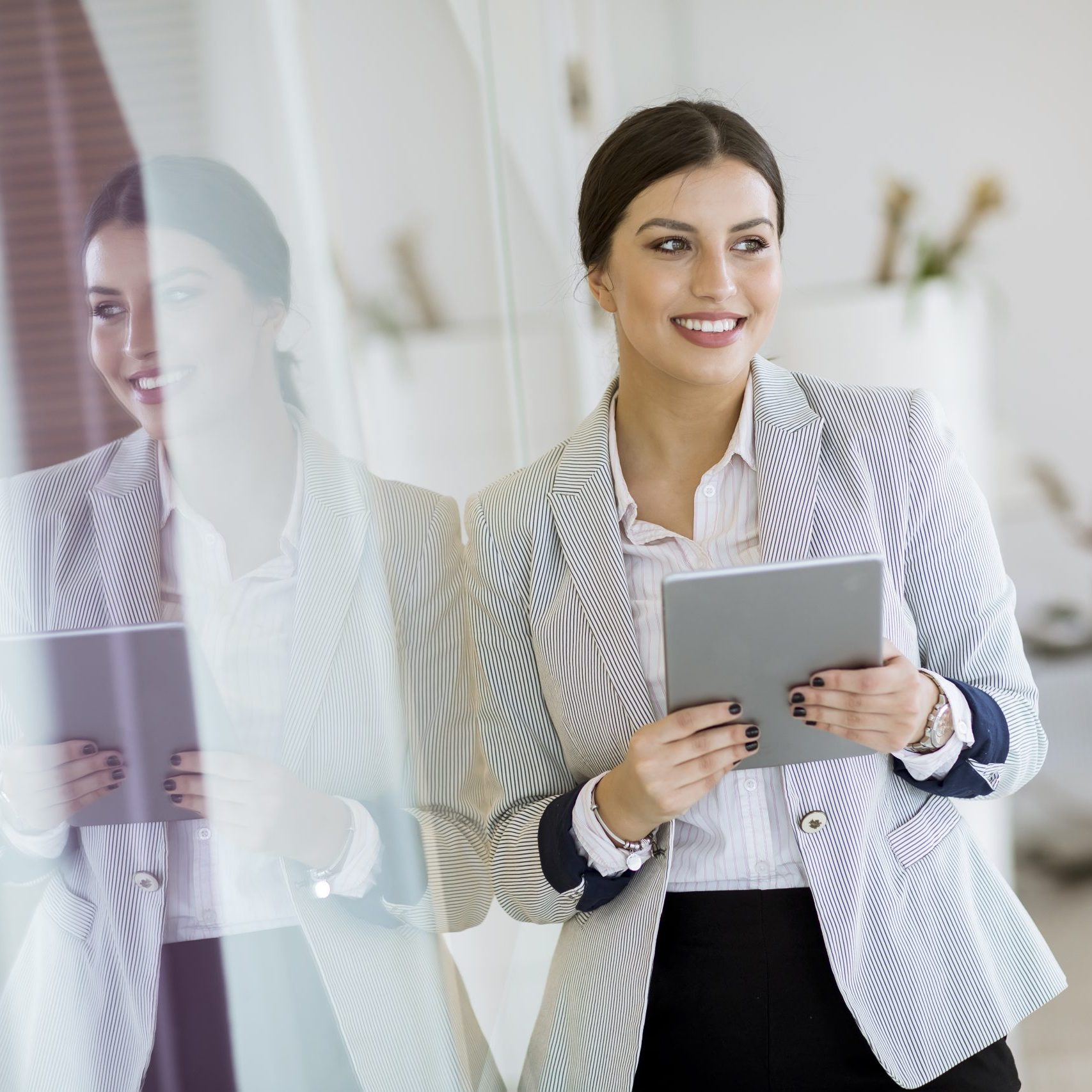 Young woman with a tablet in the office Pretty young woman with a digital tablet in the modern office