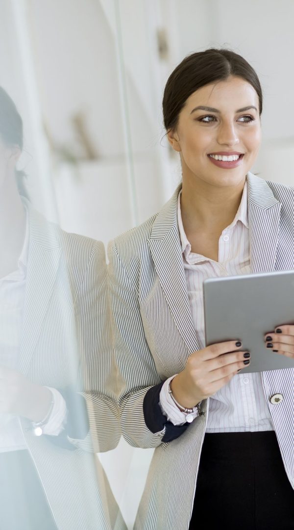 Young woman with a tablet in the office Pretty young woman with a digital tablet in the modern office